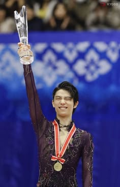 a woman holding up a trophy in front of her face and wearing a purple leotard