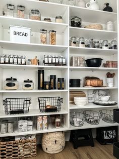 an organized pantry with white shelving and baskets on the bottom shelf, labeled bread