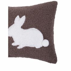 a brown and white pillow with a rabbit on it