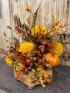 a wooden box filled with lots of different types of flowers and leaves on top of a table