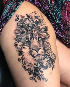 a woman's thigh with a lion and flowers on it