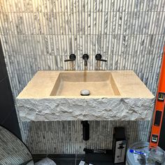 a bathroom sink sitting under a mirror next to a wall mounted faucet with two soap dispensers on it