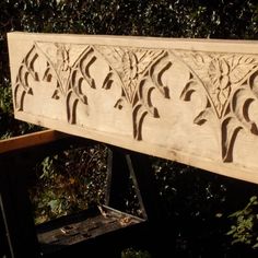 a wooden bench with carved designs on it