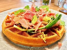 a waffle topped with bacon, lettuce and other toppings