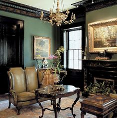 a living room filled with furniture and a chandelier hanging from the ceiling over a fire place