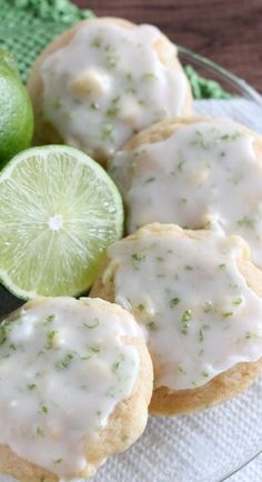 some cookies with icing and limes on a plate