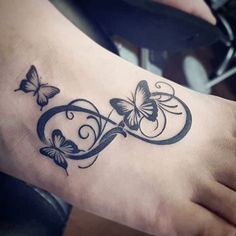 a tattoo on the foot of a woman with butterflies flying around her feet and an intertwined