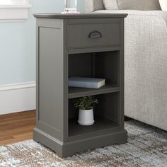 a nightstand with a book on it in front of a couch