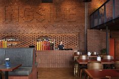 the interior of a restaurant with wooden tables and chairs, brick walls and flooring