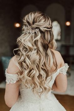 the back of a bride's head with her hair in half - up style