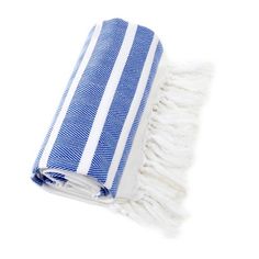 a blue and white striped beach towel folded on top of each other with fringes