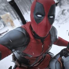 a deadpool character is standing in the snow