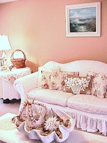 a living room filled with white furniture and lots of pillows on top of it's couches