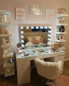 a white vanity with lights on it and a chair in front of the mirror that is lit up