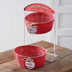 two red baskets sitting on top of a wooden table