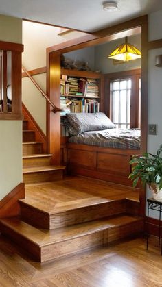 a bed sitting on top of a wooden floor next to a set of stairs