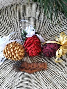 three decorative pine cones sitting on top of a woven table cloth next to a ruler