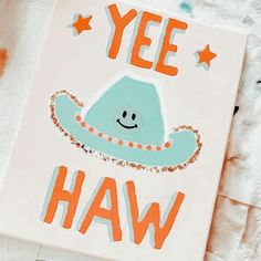 a sign that says yee haw with an image of a hat on it