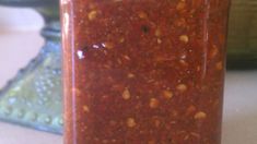 a jar filled with red sauce sitting on top of a counter