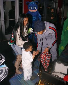 a group of people standing next to each other in front of stuffed animals and luggage