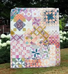 a large quilt is hanging in the grass