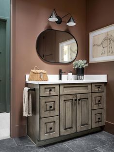 a bathroom with a sink, mirror and pictures hanging on the wall in front of it