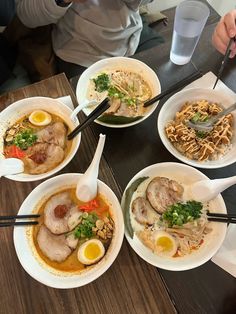 a table topped with bowls filled with different types of food and chopsticks on top of it