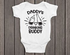 a white baby bodysuit with the words daddy's drinking buddy on it and two glasses