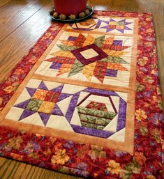 a potted plant sitting on top of a wooden floor next to a quilted table runner