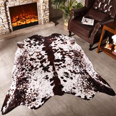 a cowhide rug in front of a fireplace