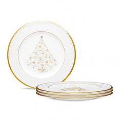 three white and gold plates with a christmas tree on one plate, the other two