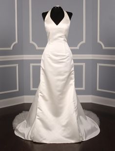 a white wedding dress on display in a room