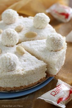 a cake with white frosting and almonds on it sitting on a blue plate