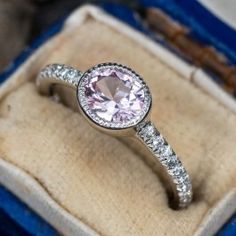 an engagement ring with a pink diamond in it