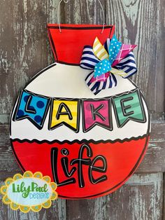 a sign that says wake life hanging on the side of a wooden door with a bow