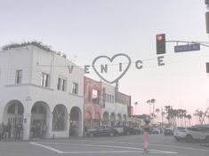 a woman crossing the street in front of a building with a heart drawn on it