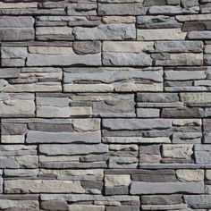 a stone wall that is made out of grey and white bricks