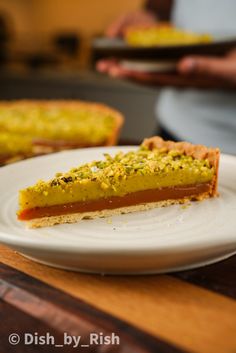 a piece of pie sitting on top of a white plate next to a wooden table