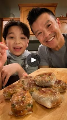 a man and boy sitting at a table with some pizzas on top of it