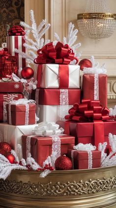 many presents are stacked on top of each other with red and white ribbons around them