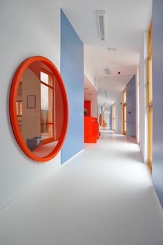 an image of a red mirror in the middle of a white room with blue walls