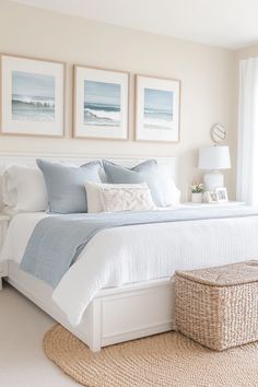 a white bed sitting in a bedroom next to two pictures on the wall above it