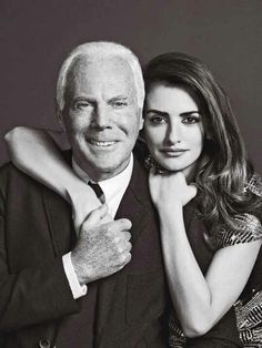 an older man and young woman posing for a black and white photo with their arms around each other