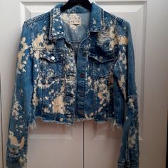 a blue jean jacket is hanging on a white door and there are holes in it