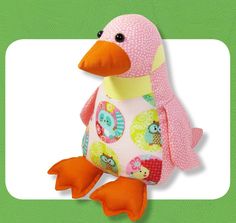 a pink duck stuffed animal sitting on top of a green background