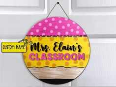 a personalized classroom door sign hanging on a white door with polka dotty dots