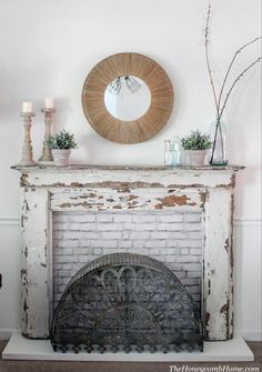 a white fireplace with a mirror above it and candles on the mantle next to it