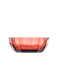 an orange glass bowl sitting on top of a white table