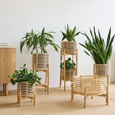 three wooden planters with plants in them sitting on the floor next to a cabinet