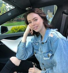 a woman sitting in the driver's seat of a car